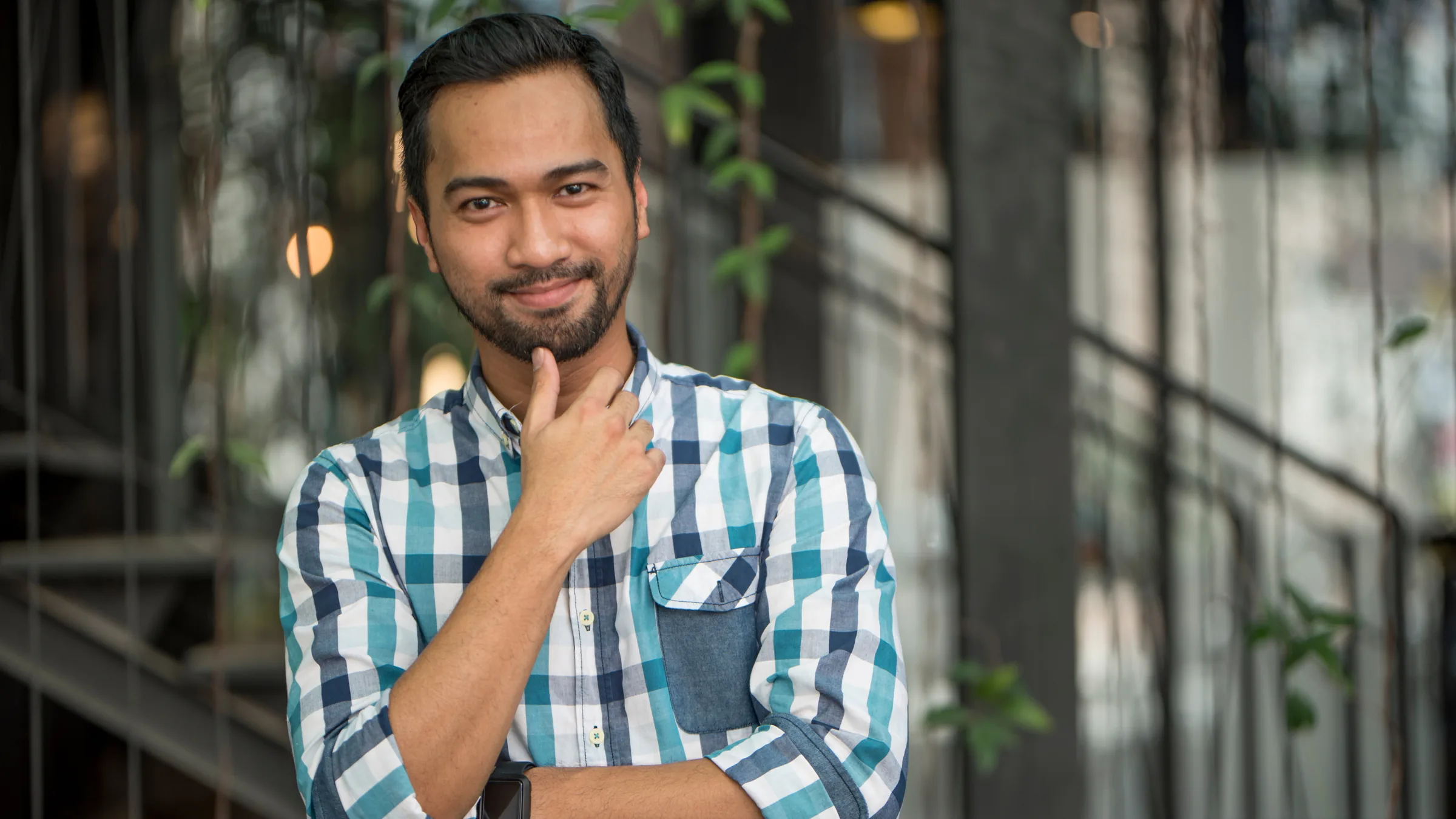 A smiling customer in a blue checked shirt